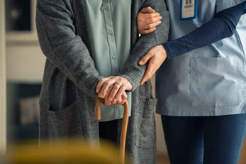 Companion-caregiver-assisting-senior-with-walking-cane-(1).png