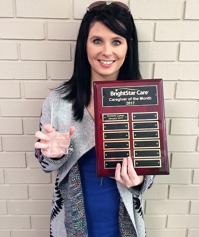 Kim Larkey holding Brightstar Care Greenville SC Caregiver Of The Month Awards
