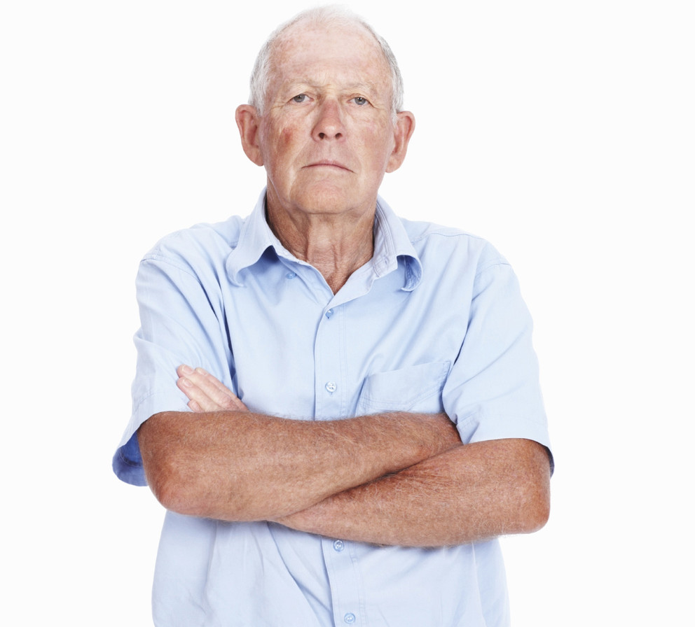 Portrait of proud senior man with hands folded over white background