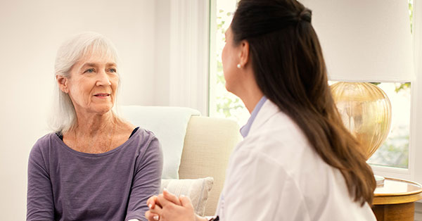 woman with caregiver looking at photo album