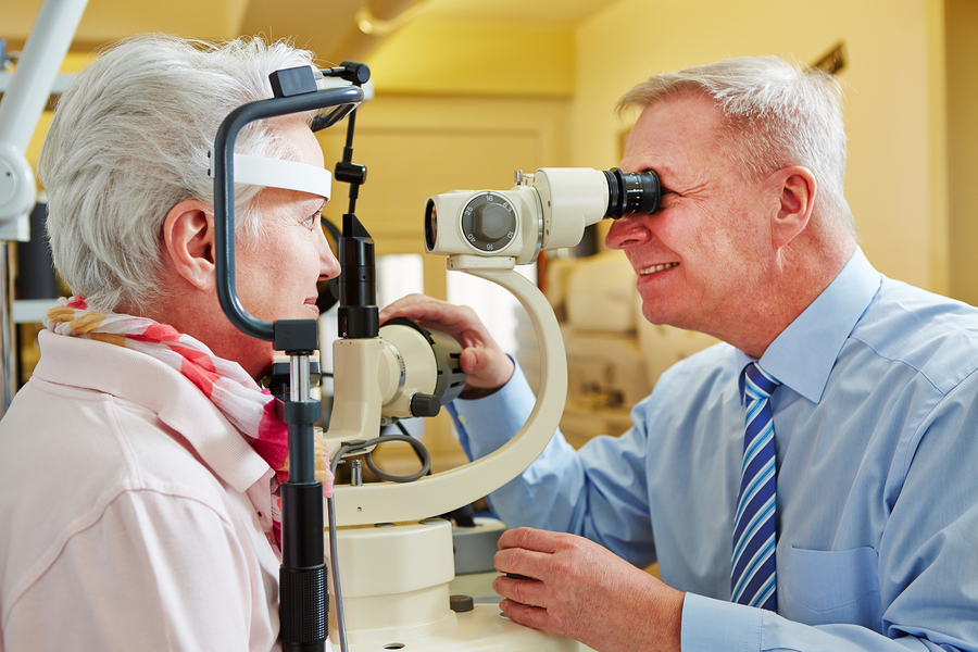 Ophthalmologist examing cornea of senior woman with slit lamp