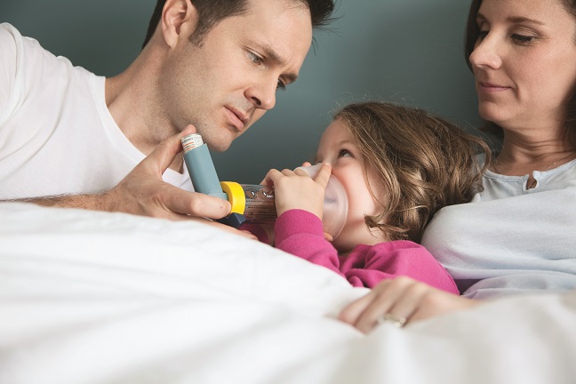 Parents in bed with their sick daughter