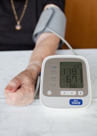 Senior woman measuring her blood pressure. At home