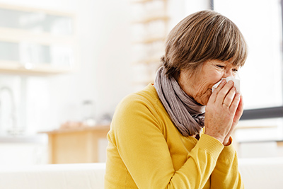 Elder woman blowing nose