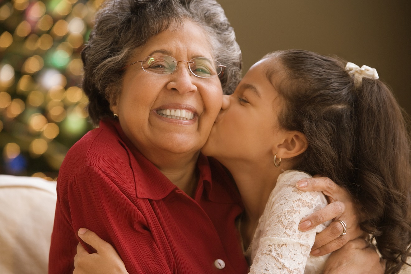 Young girl kissing Alzheimer's patient on the cheek